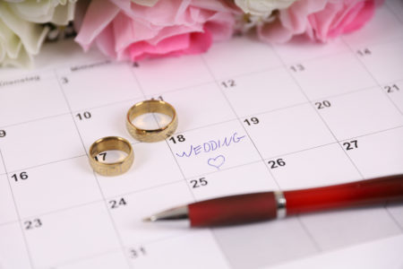Wedding date on calendar with gold wedding rings