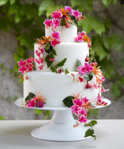 White 3 tiered cake with real red and pink flowers