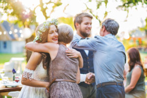 Guests hugging bride and groom at wedding
