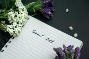 Handwritten guest list with purple and white flowers