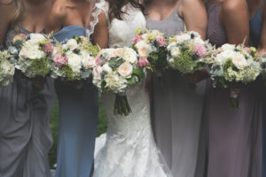 Closeup of bride and bridesmaids holding beautiful pink, white, and green wedding day bouquets